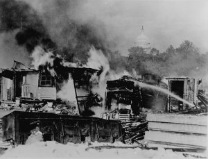 Shacks, put up by the Bonus Army on the Anacostia flats, Washington, D.C., burning after the battle with the military. The Capitol in the background. 1932.